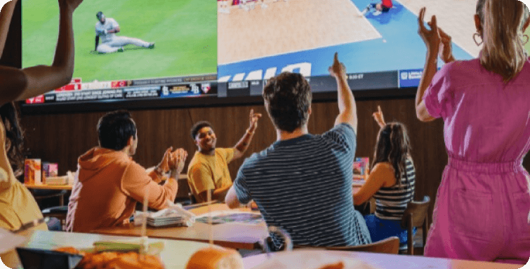 Enjoying food at dave & busters restaurant with sports watching on big screen